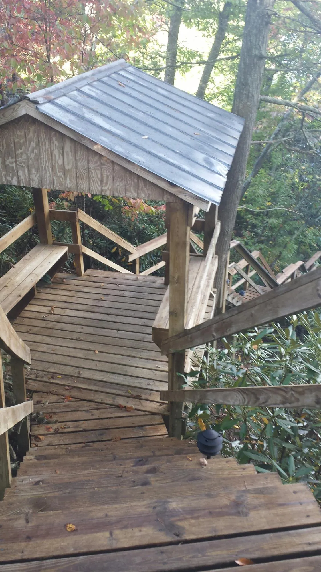 Metal roofed shelter over wooden steps on a wooded walkway — Skylight Repair & Installation work by our crew in West Sunbury