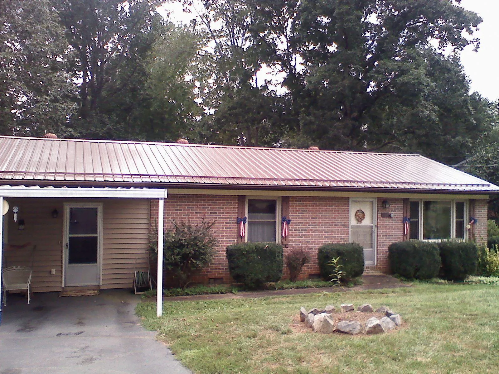 Bronze metal roof and carport on a brick ranch home — Roof Repair work by our crew in West Sunbury